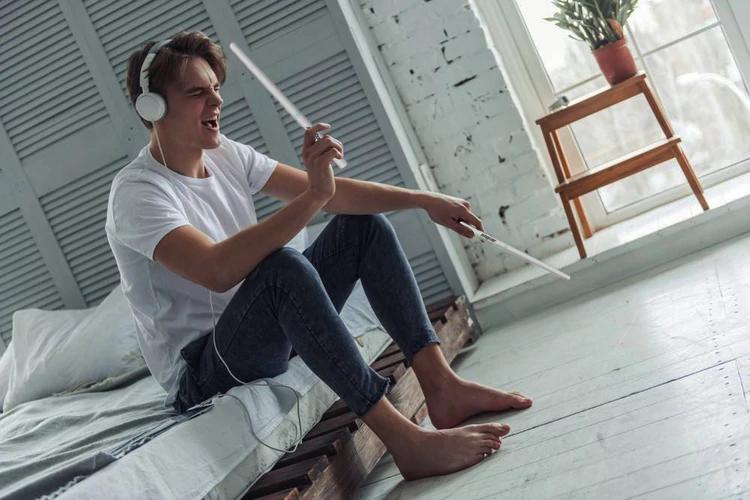 A man is using a PocketDrum 2 Max to practice rhythm