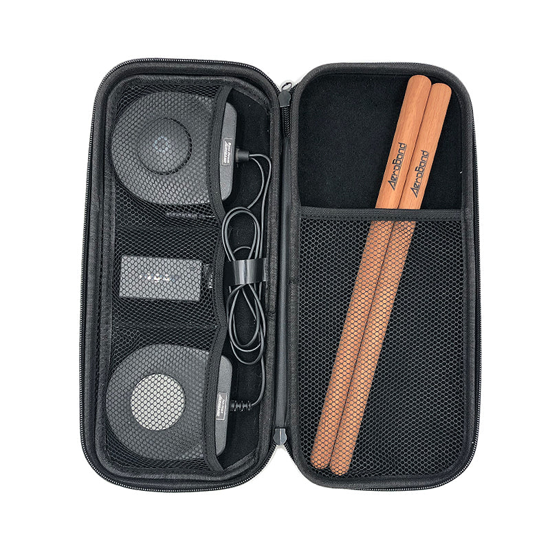 Opened black PocketDrum storage bag with AeroBand drumsticks, pedals, receiver and cables in mesh pockets.
